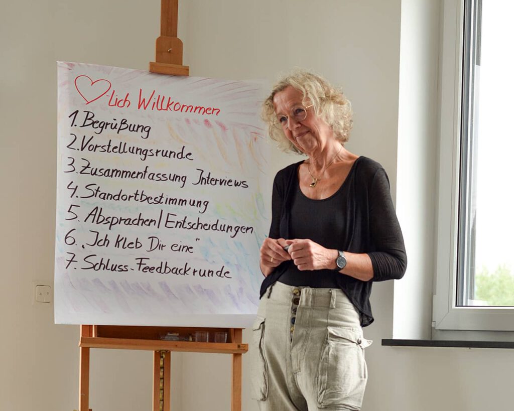 a woman standing in front of a white board