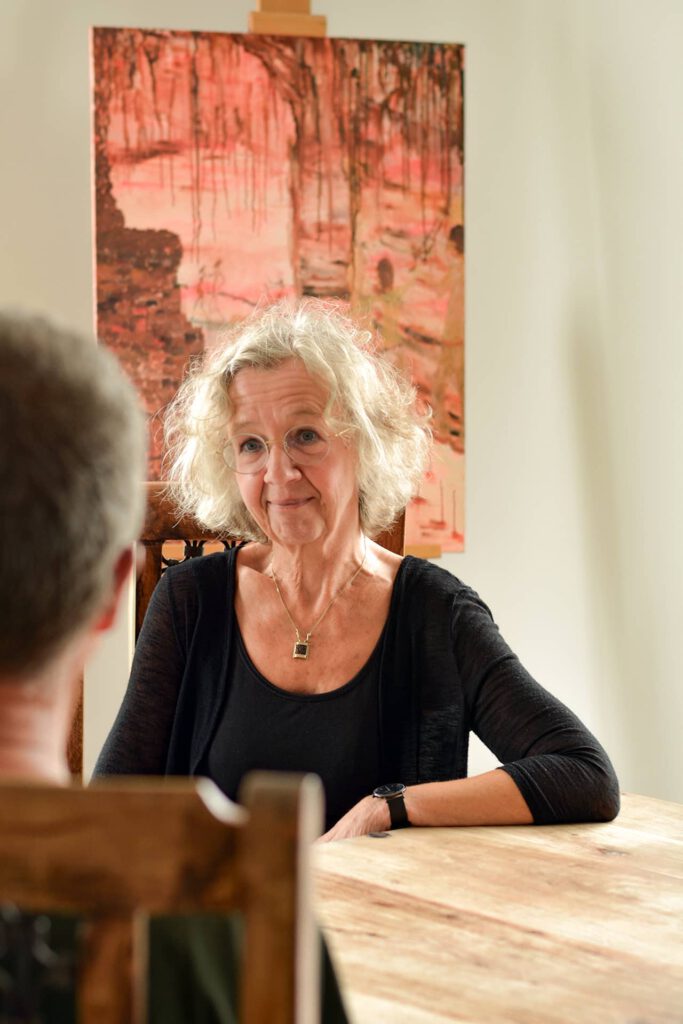 a woman sitting at a table talking to a client